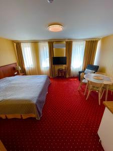 Habitación de hotel con cama y alfombra roja en JūRa 28, en Klaipėda