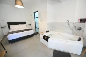 a bedroom with a bed and a tub in a room at Suites in the Galilee in Qiryat Shemona