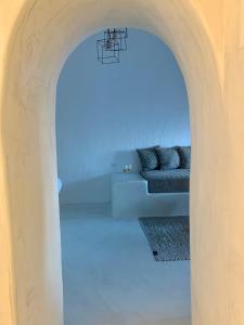 a living room with a couch under an archway at White Curves Santorini in Akrotiri