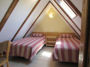 a attic room with two beds and a window at Glamping Narnia in Bovec