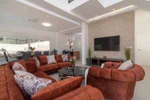 uma sala de estar com sofás laranja e uma televisão em Luxury Villa Sun Stone heated pool & whirlpool em Trogir