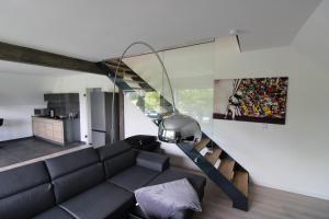 a living room with a black couch and a spiral staircase at Maisonette-Wohnung Oststraße 37 in Schmallenberg