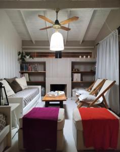 een woonkamer met een bank en een plafondventilator bij LAS ORQUIDEAS in Plottier