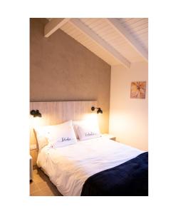 1 dormitorio con 1 cama grande con sábanas blancas en LAS ORQUIDEAS en Plottier