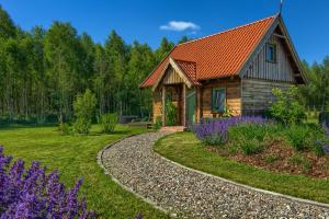 a house with an orange roof and a garden with purple flowers at Zielone Ławki in Ryn