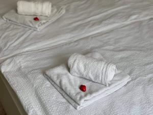 two white towels with red hearts on a white bed at Apartman-Florianska in Košice
