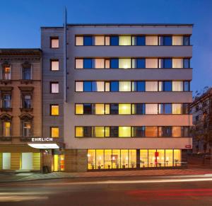 ein hohes Gebäude mit vielen Fenstern auf einer Straße in der Unterkunft Hotel Ehrlich Prague in Prag