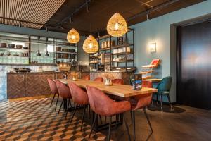 een restaurant met een houten tafel en stoelen bij Hotel-Appartementen Klaver Vier in Wagenborgen