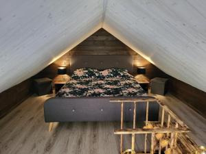 a bed in the middle of a attic with two tables at Tiny house near Viljandi lake in Viljandi