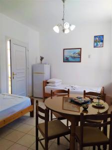 a room with two beds and a table and chairs at Elli Studios & Apartments in Marathokampos