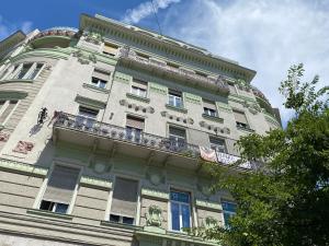 ein hohes Gebäude mit Balkon darüber in der Unterkunft Stylish Apartment by the Vígszínház Theater in Budapest