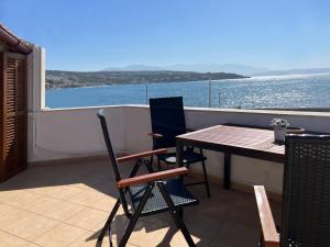 una mesa y sillas en un balcón con vistas al agua en Amalia's House, en Rethymno