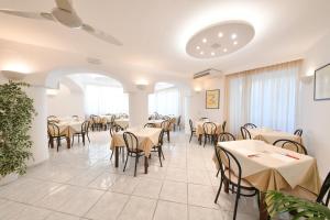 a restaurant with tables and chairs in a room at Hotel Noris in Ischia Town