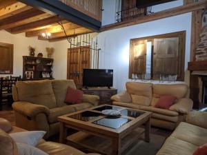 a living room with couches and a coffee table at Casa rural El Arroyo in Migueláñez