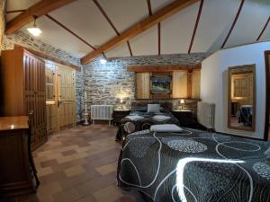 a bedroom with two beds and a stone wall at Casa rural El Arroyo in Migueláñez