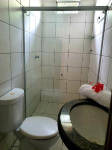 a bathroom with a shower with a toilet and a sink at Pousada Corais Do Sul in Caraíva