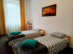 クラクフにあるJoApart - Stare Podgórzeのベッド2台が備わる部屋、壁に絵が飾られた部屋