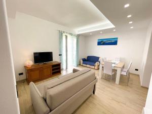 a living room with a couch and a tv and a table at Maison Marinella in Ischia