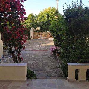 a garden with flowers and a wooden fence at Elli Studios & Apartments in Marathokampos