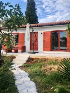 een huis met rode deuren en een loopbrug bij Villa Marija in Vrsar