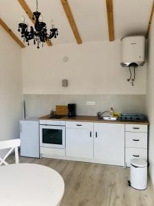 a kitchen with white cabinets and a sink and a table at Villa Marija in Vrsar