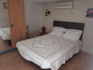 a bedroom with a bed with white sheets and pillows at Les Gites de Kevinou in Vallon-Pont-dʼArc