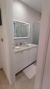 a white bathroom with a sink and a mirror at Casa para ti Villa in Porto Heli