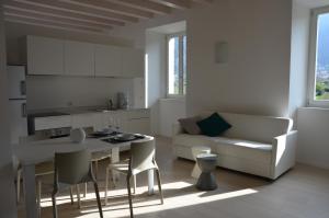 a kitchen and living room with a table and a couch at Palazzo Oltre in Arco
