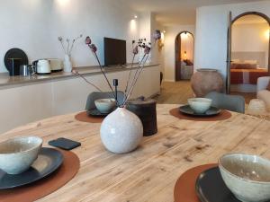 una mesa de madera con platos y un jarrón. en Malaga stylish beach apartments, en Málaga