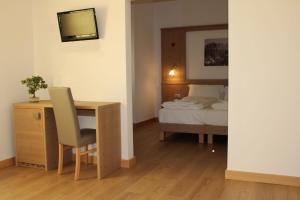 um quarto com uma secretária, uma cama, uma secretária e uma cadeira. em Residence Panorama em Val di Zoldo