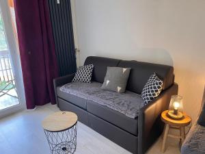 a living room with a couch with pillows on it at Christiana studios en hyper centre de Valberg aux pieds des pistes in Valberg