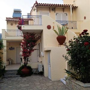 a house with flower pots on the side of it at Elli Studios & Apartments in Marathokampos