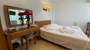 1 dormitorio con cama y mesa con espejo en Sor Inn Holiday, en Eforie Nord