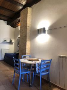 uma mesa de jantar com cadeiras azuis e uma luz em La Casina di Tonia em Terracina