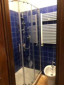 uma casa de banho em azulejos azuis com um chuveiro e um WC em La Casina di Tonia em Terracina