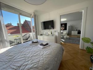 1 dormitorio con cama grande y ventana grande en PANORAMIC FAMILY APT with FREE TWO PARKING PLACE AND BREAKFAST, en Budapest