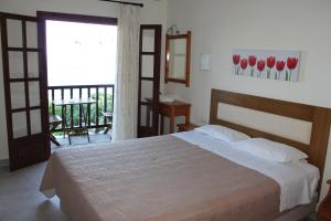 ein Schlafzimmer mit einem großen Bett und einem Balkon in der Unterkunft To Mpalkoni in Khorevtón