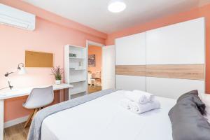 1 dormitorio con cama blanca y escritorio en Precioso Apartamento en el Centro de Granada, en Granada