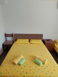 Una cama amarilla con dos almohadas. en Apartments Ivana, en Ulcinj