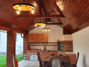 a kitchen with a wooden ceiling and a table with chairs at Casa Irina in Horezu