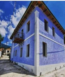 un edificio azul y blanco con balcón en Theokleia_guest house, en Kavala