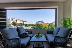 a balcony with blue furniture and a large window at Mrak Zadar Exclusive in Zadar