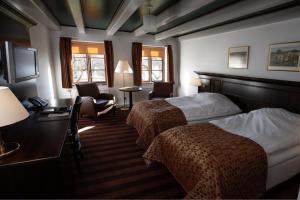 Ans的住宿－Hotel Kongensbro Kro，酒店客房带两张床、一张桌子和椅子。