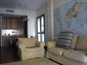 a living room with two chairs and a map on the wall at Olles Apartment in Barcelona