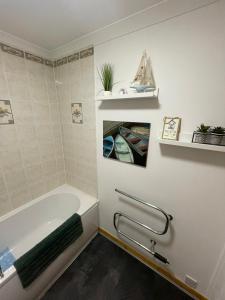 Self Catering Spacious 2 Bed Apartment with sea views في South Erradale: حمام مع حوض استحمام ومغسلة