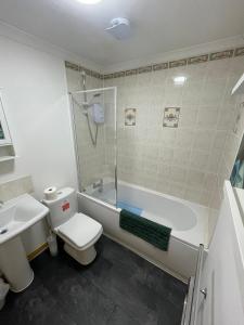 uma casa de banho com um WC, uma banheira e um lavatório. em Self Catering Spacious 2 Bed Apartment with sea views em South Erradale