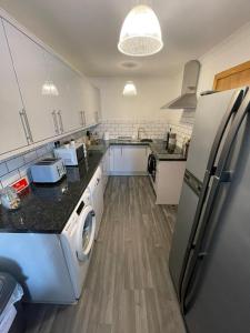 a kitchen with a refrigerator and a washer at Self Catering Spacious 2 Bed Apartment with sea views in South Erradale