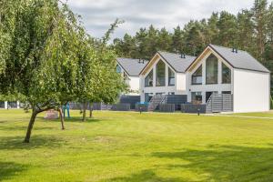 een huis in een park met groen gras bij Domy Morskie Dog Friendly in Jantar