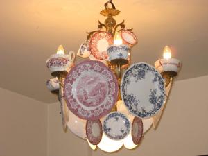 a chandelier with blue and white plates and candles at Olles Apartment in Barcelona
