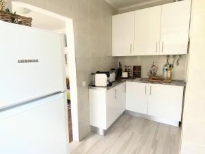 a kitchen with white cabinets and a refrigerator at Portuguese apartment in the heart of Lisbon in Lisbon
